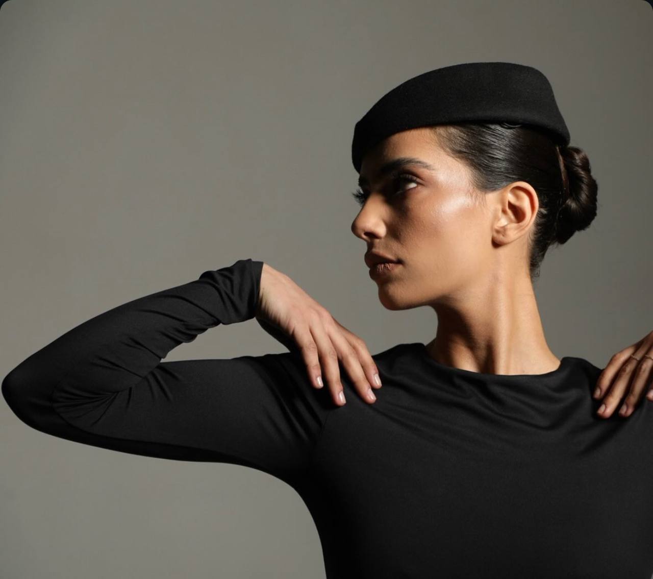 Editorial portrait of a woman in a black beret gazing off camera